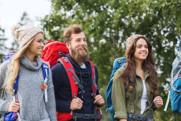 Grupo de amigos sonrientes con mochilas senderismo — Foto de Stock