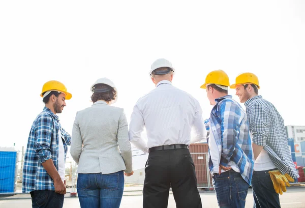 Grupo de construtores e arquitetos no canteiro de obras — Fotografia de Stock