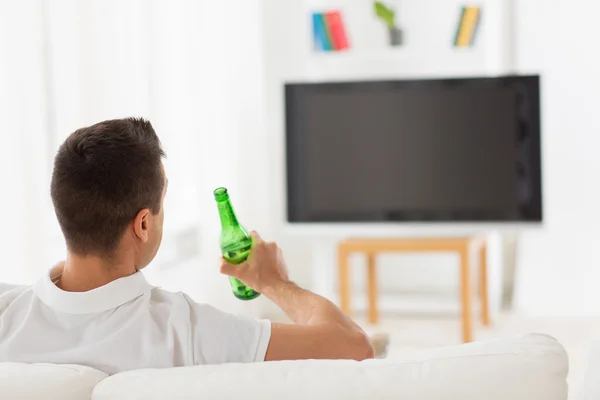 Hombre viendo la televisión y bebiendo cerveza en casa — Foto de Stock