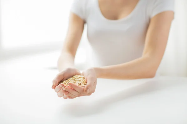 Primer plano de las manos de la mujer sosteniendo copos de avena —  Fotos de Stock