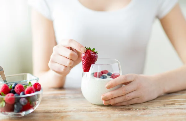 Primer plano de las manos de la mujer con yogur y bayas —  Fotos de Stock