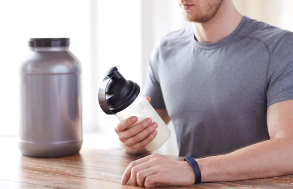 Nahaufnahme eines Mannes mit Protein-Shake-Flasche und Glas — Stockfoto