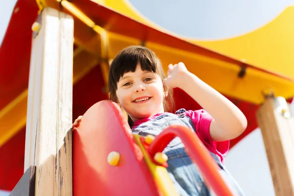 Fröhliches kleines Mädchen klettert auf Kinderspielplatz — Stockfoto