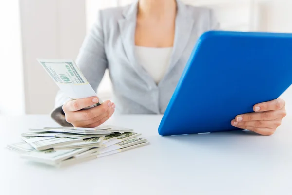 Primer plano de las manos de la mujer con la tableta PC y el dinero — Foto de Stock