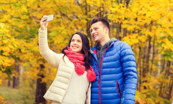 Coppia sorridente che si abbraccia nel parco autunnale — Foto Stock