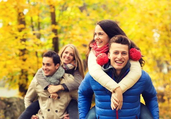 Amis souriants s'amuser dans le parc d'automne — Photo