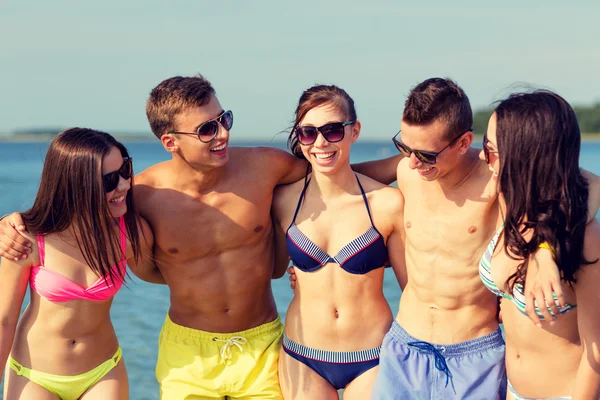 Lachende vrienden in zonnebril op zomer strand — Stockfoto