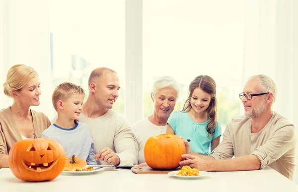 Happy family sitting with pumpkins at home — Stock Photo, Image