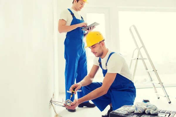 Builders with tablet pc and equipment indoors Royalty Free Stock Photos