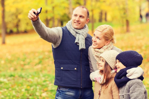 Famiglia felice con macchina fotografica nel parco autunnale — Foto Stock