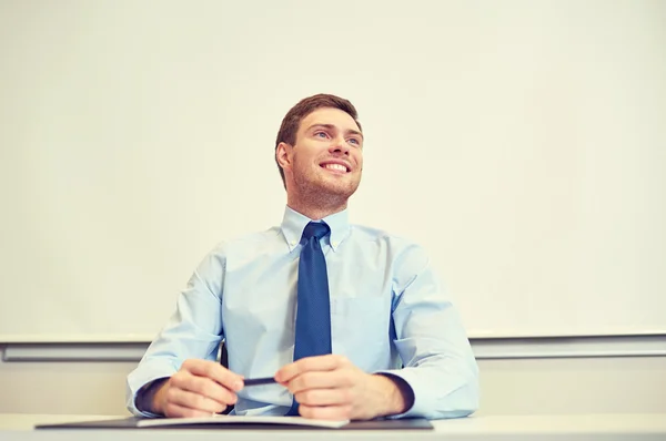 Uśmiechający się biznesmen siedzi w biurze — Zdjęcie stockowe