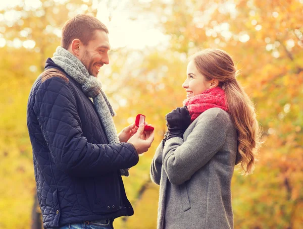 Coppia sorridente con anello di fidanzamento in confezione regalo — Foto Stock