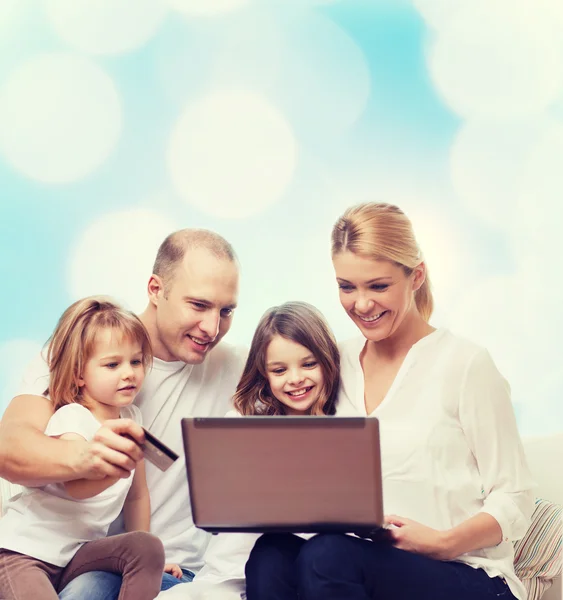 Familia feliz con ordenador portátil y tarjeta de crédito —  Fotos de Stock