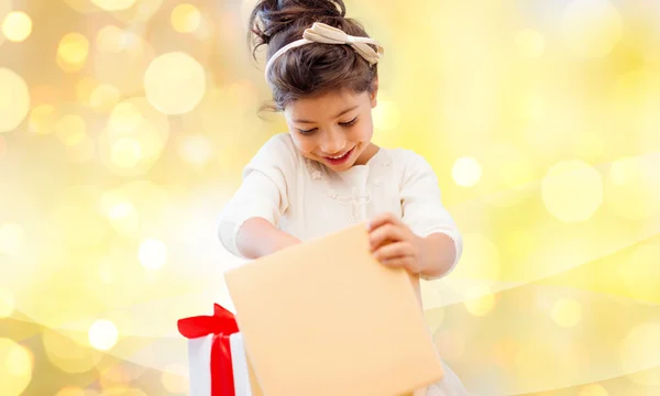 Smiling little girl opening gift box — Stock Photo, Image