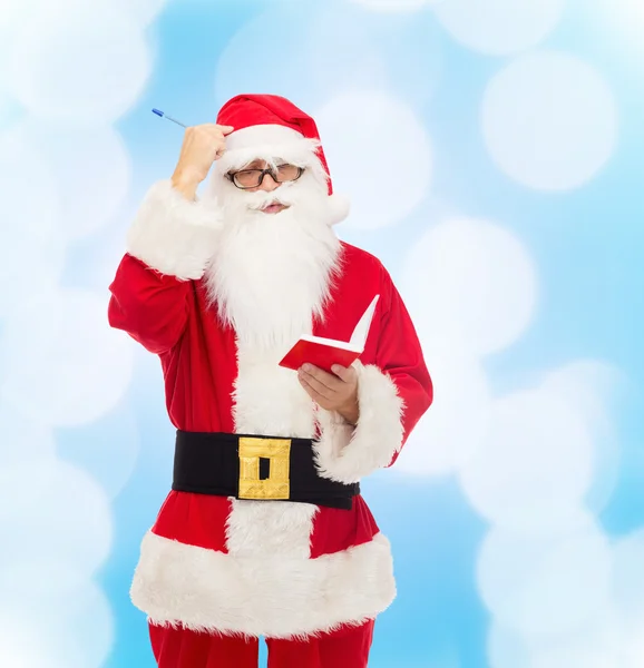 Man in kostuum van de kerstman met Kladblok — Stockfoto