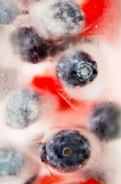 Primo piano di acqua di frutto con cubetti di ghiaccio sopra vetro — Foto Stock