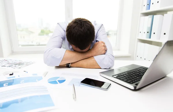 Geschäftsmann mit Laptop und Papieren im Büro — Stockfoto