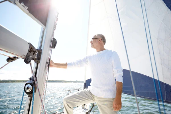 Senior man op zeil boot of jacht zeilen in zee — Stockfoto