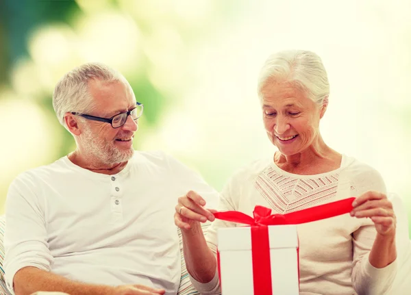 Gelukkig senior paar met geschenkdoos thuis — Stockfoto