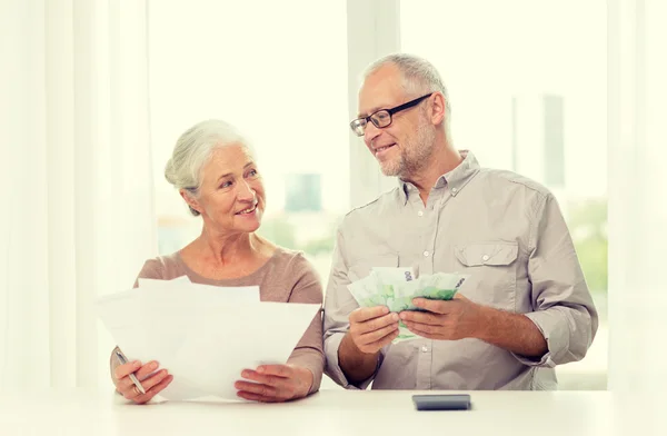 Senior couple with money and calculator at home — Stock Photo, Image