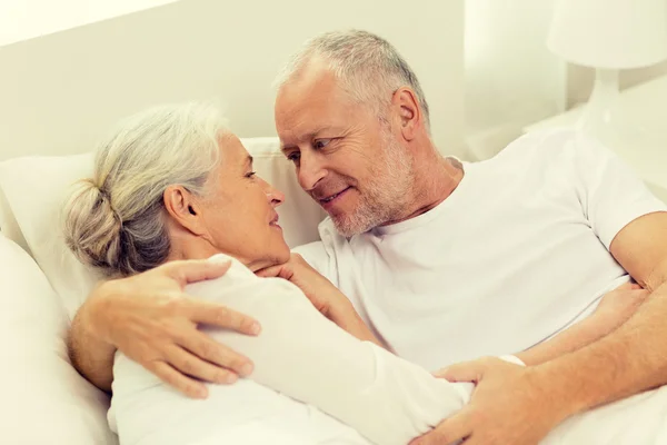 Happy senior coupler lying in bad at home — Stock Photo, Image