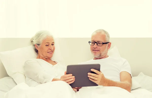 Šťastný starší pár s tablet pc doma — Stock fotografie