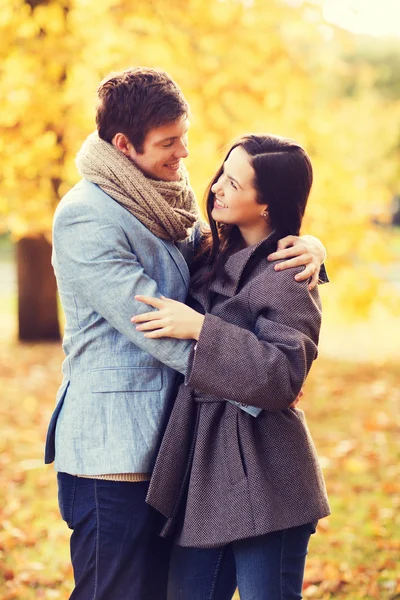 Casal sorridente abraçando no parque de outono — Fotografia de Stock