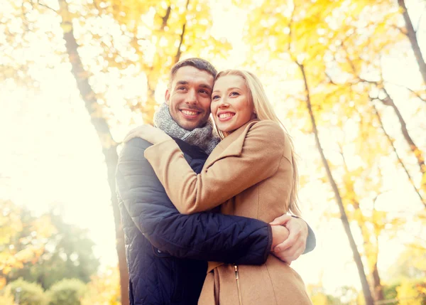 Casal sorridente abraçando no parque de outono — Fotografia de Stock