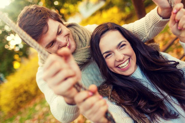 Coppia sorridente che si abbraccia nel parco autunnale — Foto Stock