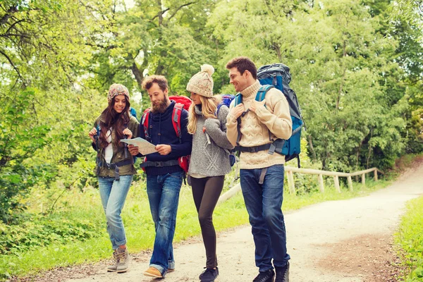 Grupo de amigos sonrientes con mochilas senderismo — Foto de Stock