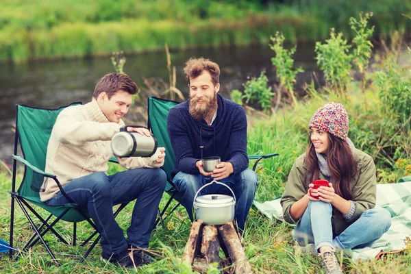 Group of smiling tourists cooking food in camping — Stock Photo, Image