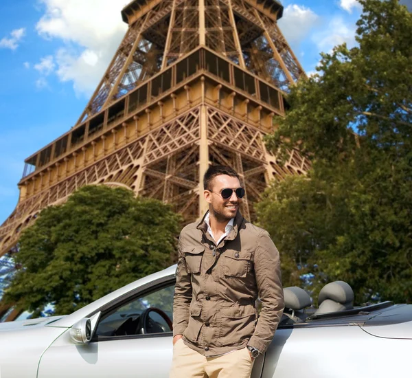 Щасливий чоловік біля кабріолетного автомобіля над Ейфелевою вежею — стокове фото