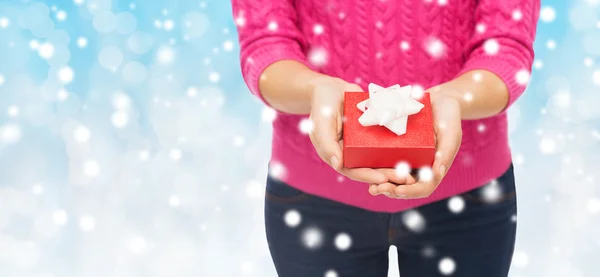 Close up of woman in pink sweater holding gift box — Stock Photo, Image