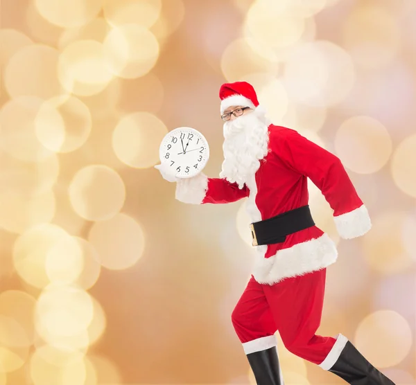 Man in costume of santa claus with clock — Stock Photo, Image