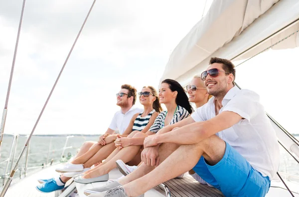 Amici sorridenti seduti sul ponte dello yacht — Foto Stock