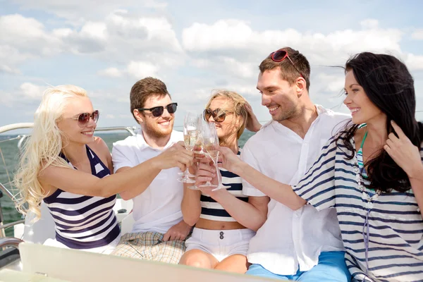 Amigos sonrientes con copas de champán en el yate —  Fotos de Stock