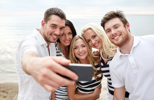 Amigos felizes na praia e tirar selfie — Fotografia de Stock