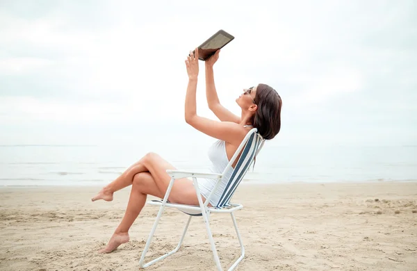 Glad kvinna med TabletPC med selfie på stranden — Stockfoto