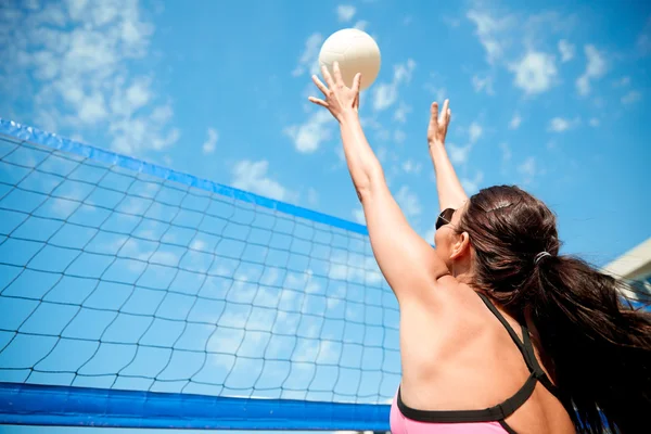Mladá žena s míčem hrát volejbal na pláži — Stock fotografie