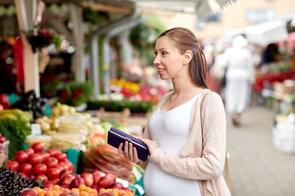Donna incinta con portafoglio comprare cibo al mercato — Foto Stock