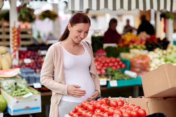 Mujer embarazada eligiendo comida en el mercado callejero —  Fotos de Stock