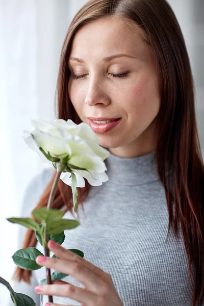 Glückliche Frau riecht große weiße Rose zu Hause — Stockfoto