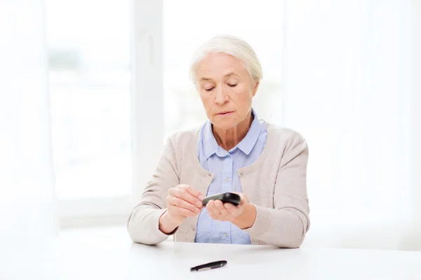 Äldre kvinna med Glukometer kontrollera blodsocker — Stockfoto