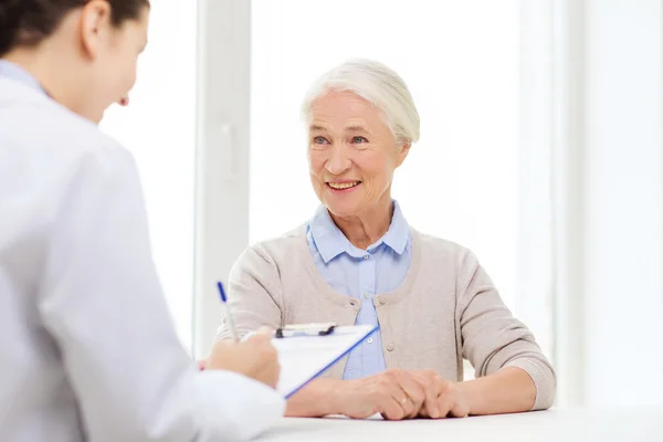 Médecin avec presse-papiers et femme âgée à l'hôpital — Photo