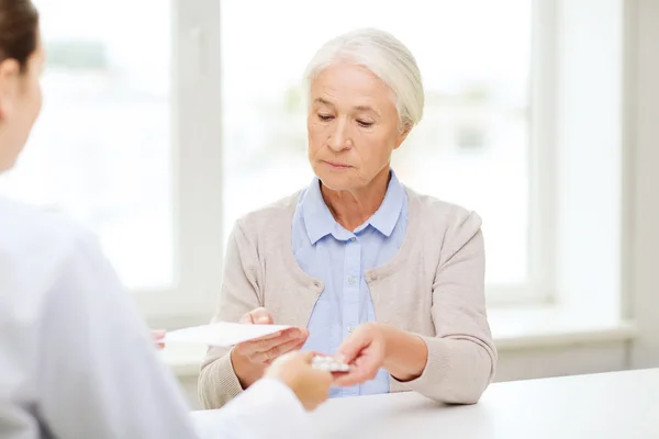 Médico que da prescripción y medicamento a la mujer —  Fotos de Stock