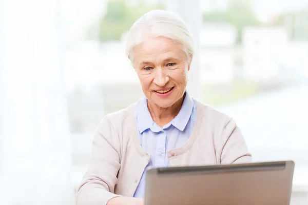 Mulher sênior feliz com laptop em casa — Fotografia de Stock