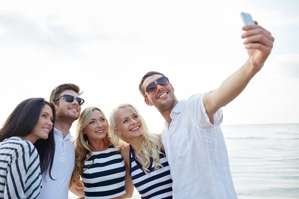 Happy friends on beach and taking selfie Stock Image
