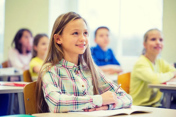 Grupo de escolares con cuadernos en el aula — Foto de Stock