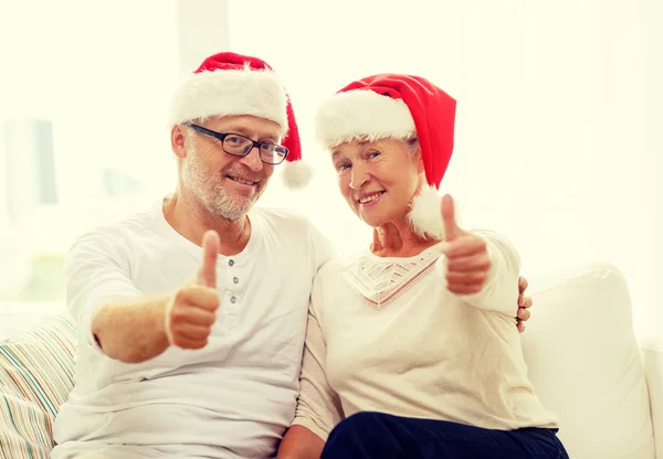 Gelukkig senior koppel in santa hoeden thuis helper — Stockfoto