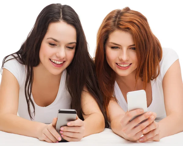 Two smiling teenagers with smartphones — Stock Photo, Image